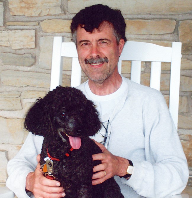 Author Allen McCaulley with a black poodle.